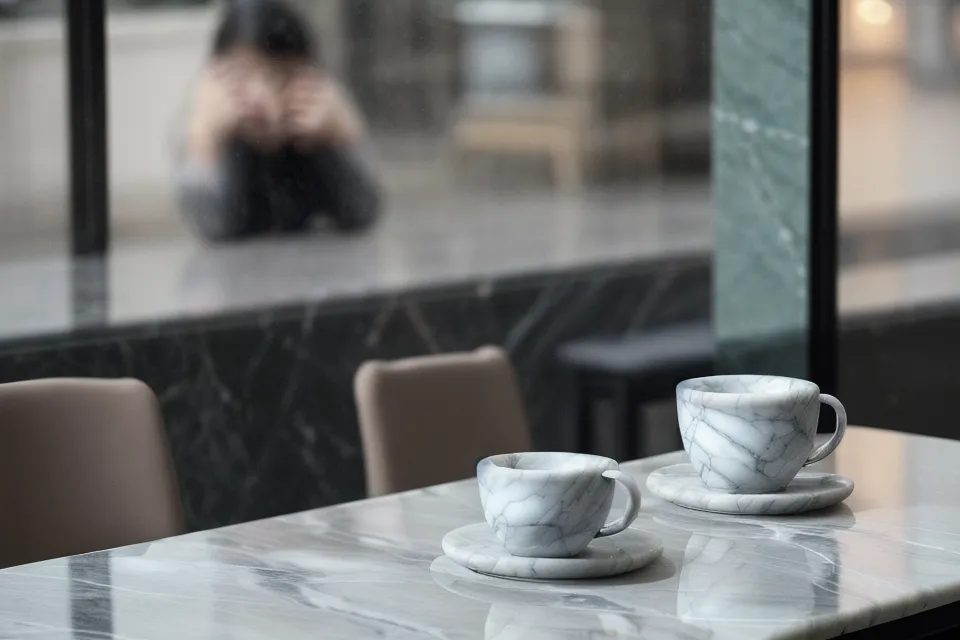 Gros plan de mains tenant un smartphone éclairé par l'écran d'une appli de rencontre, analyse de bio en cours